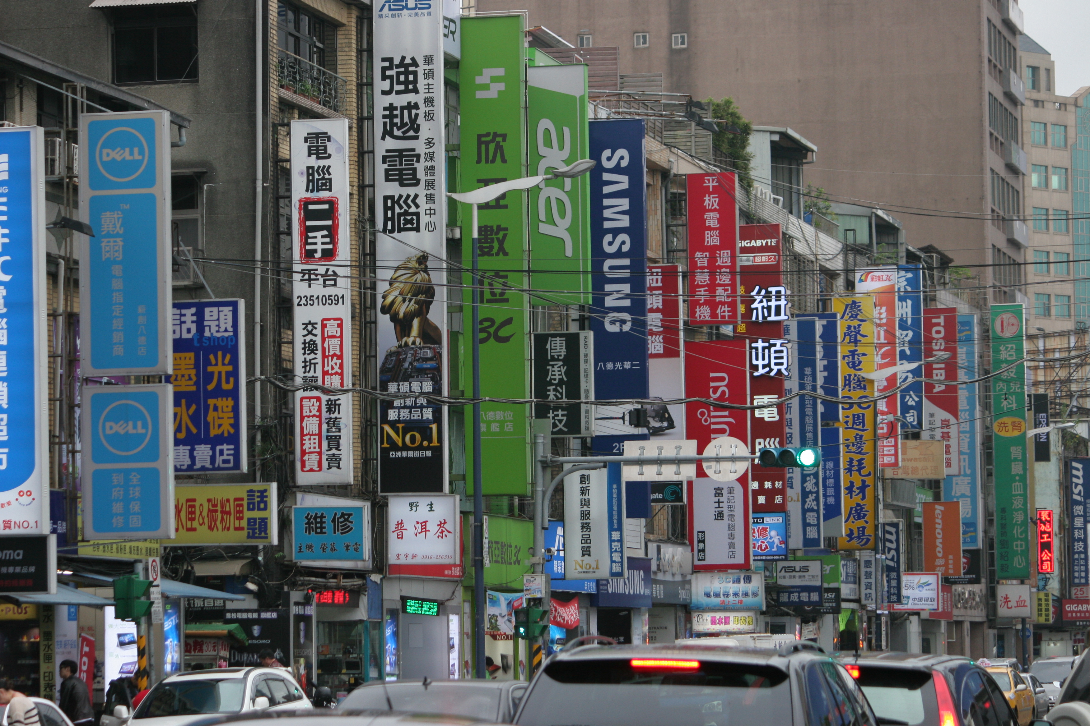 Taipei street scene — dense vertical signage in Chinese and English along a busy urban boulevard